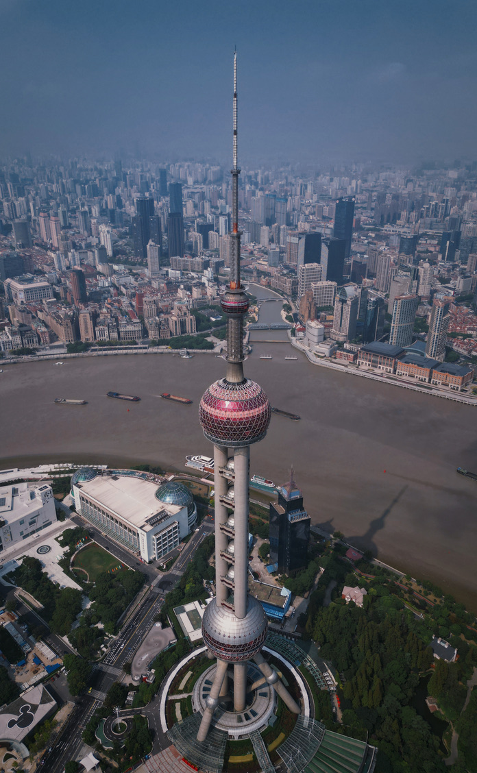 Aerial view of the Oriental Pearl Tower rising over the Huangpu River and the Shanghai skyline
